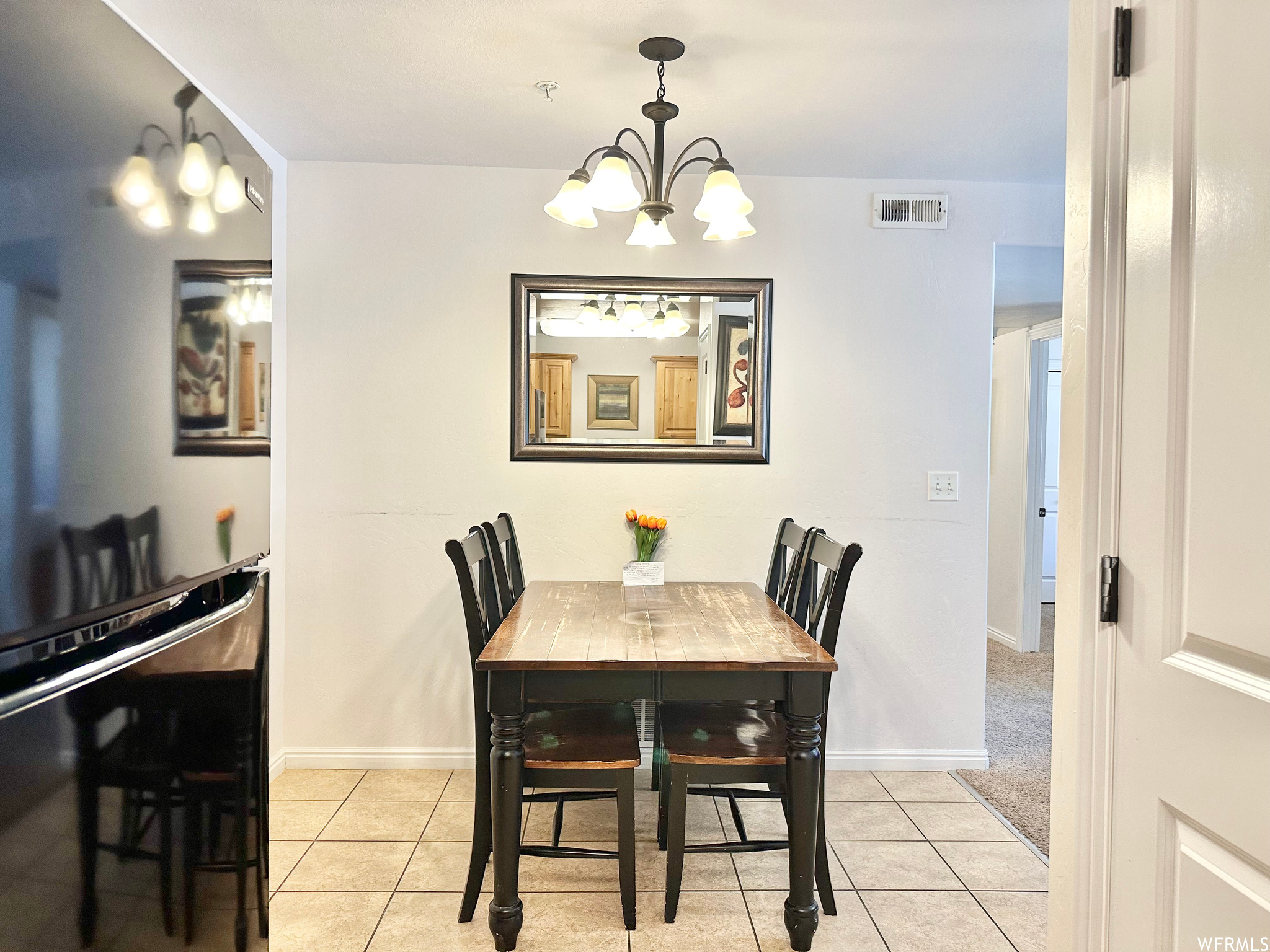 Dining space featuring an inviting chandelier and light tile floors