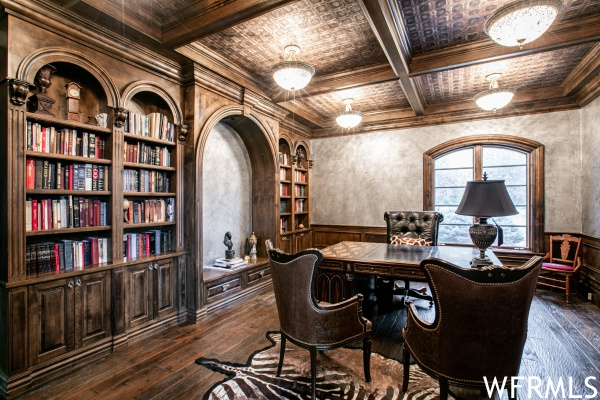 Office featuring coffered ceiling, dark hardwood floors, built in shelves, beam ceiling, and ornamental molding