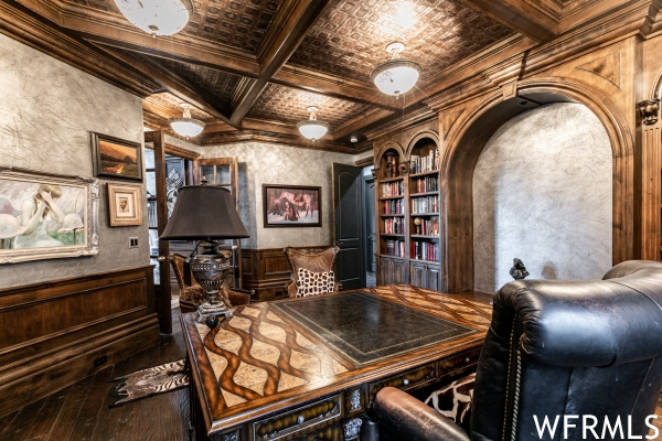 Office area featuring coffered ceiling, hardwood floors, beamed ceiling, built in shelves, and ornamental molding