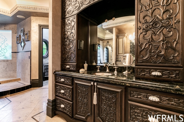 Bathroom featuring crown molding, vanity, and tile flooring