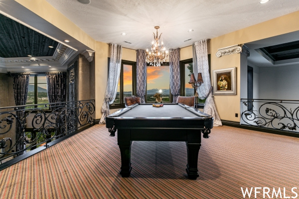 Rec room with a raised ceiling, a chandelier, pool table, and carpet