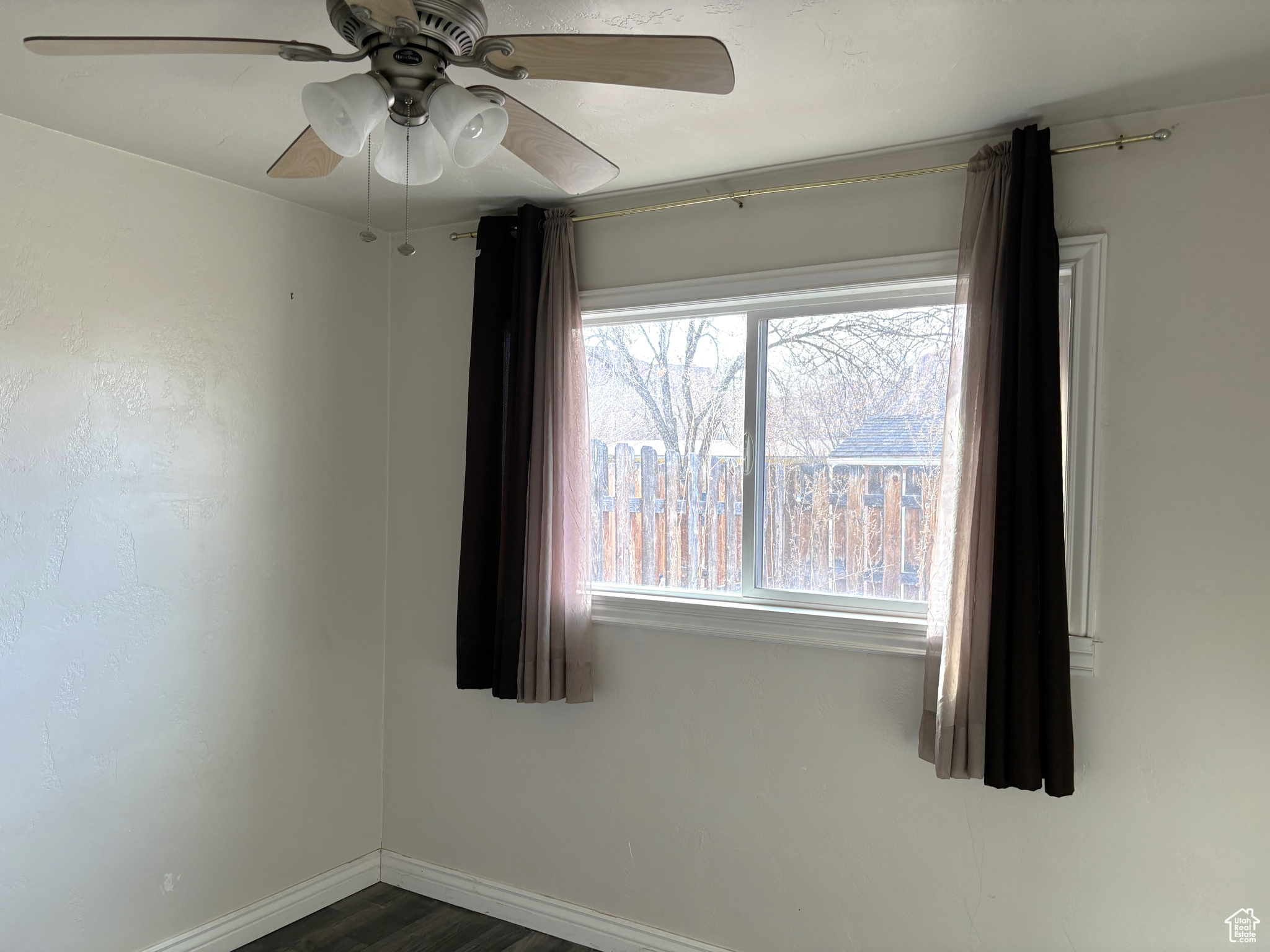 Unfurnished bedroom 2 with a healthy amount of sunlight, dark hardwood / wood-style floors, and ceiling fan