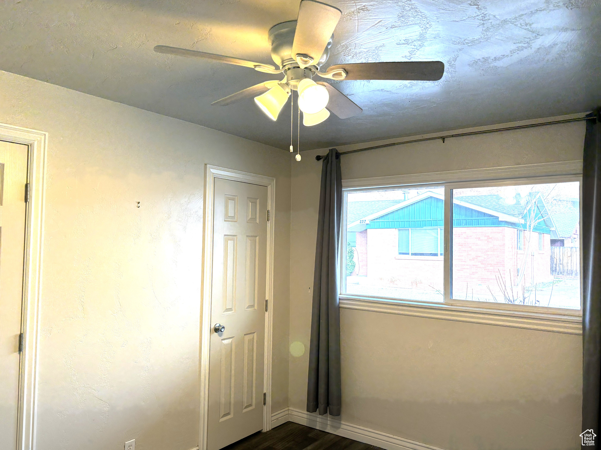 Unfurnished bedroom 1 featuring dark hardwood / wood-style floors and ceiling fan