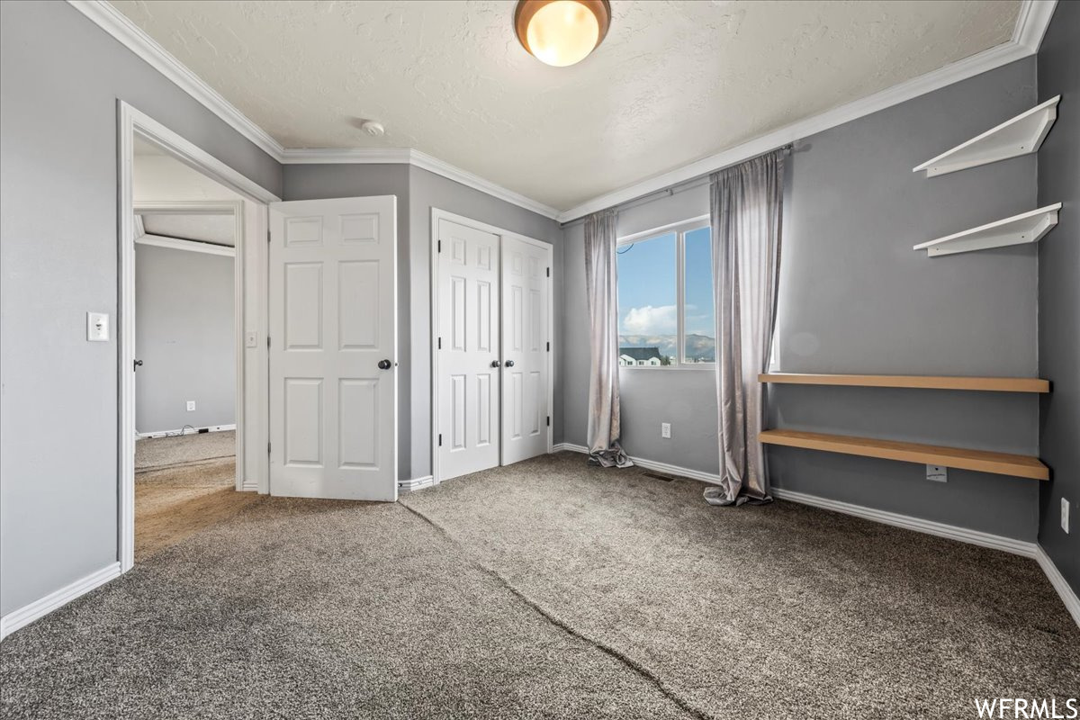 Unfurnished bedroom with light carpet and ornamental molding