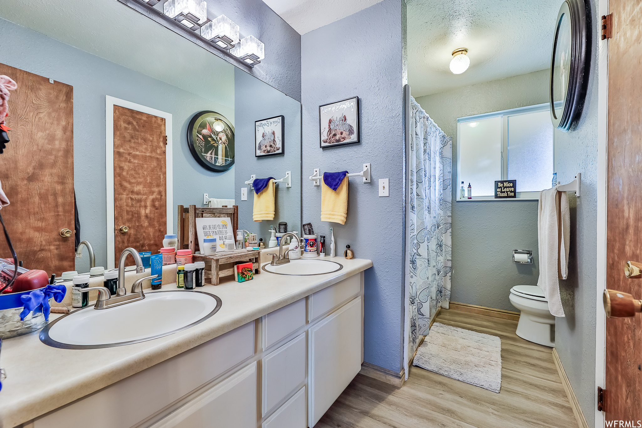 Bathroom featuring oversized vanity, hardwood / wood-style flooring, toilet, and double sink