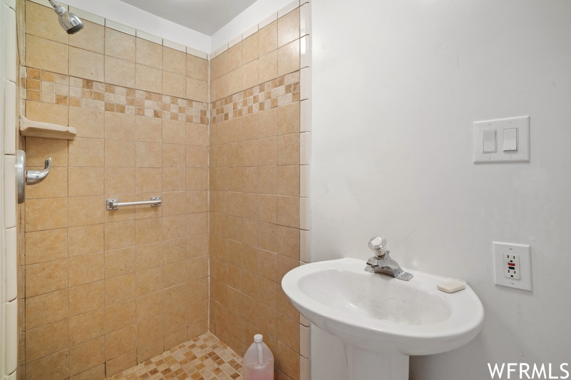 Bathroom featuring tiled shower and sink