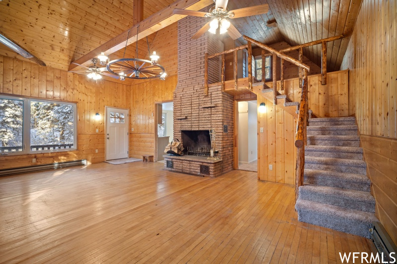 Unfurnished living room featuring wood walls and light hardwood / wood-style flooring