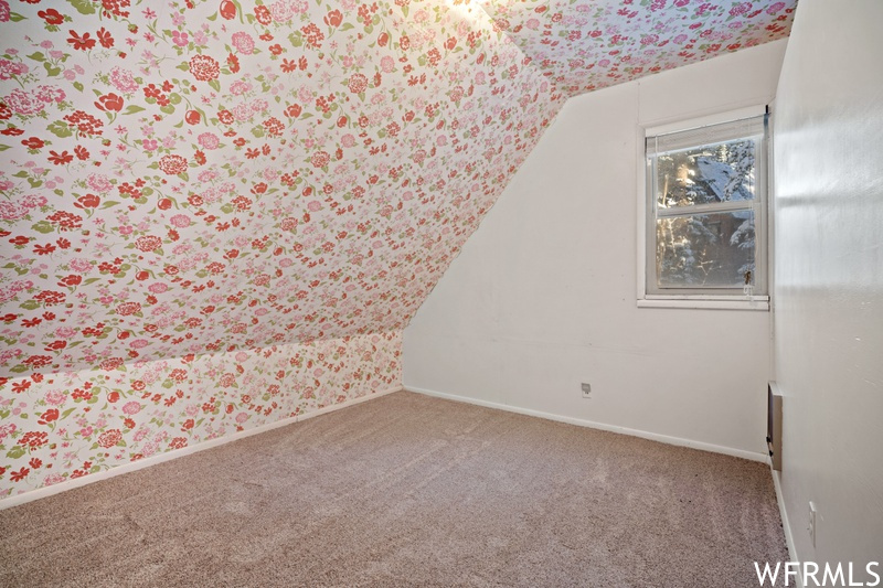 Bonus room with carpet flooring and lofted ceiling