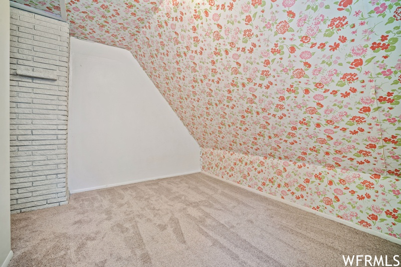 Interior space with light carpet and brick wall