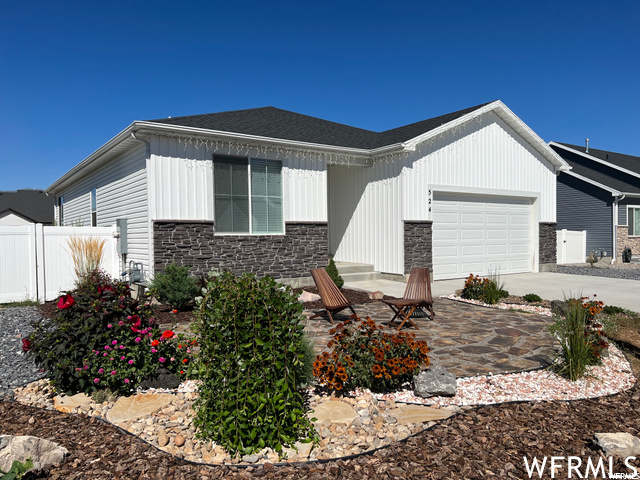 View of front of property with a patio area and a garage