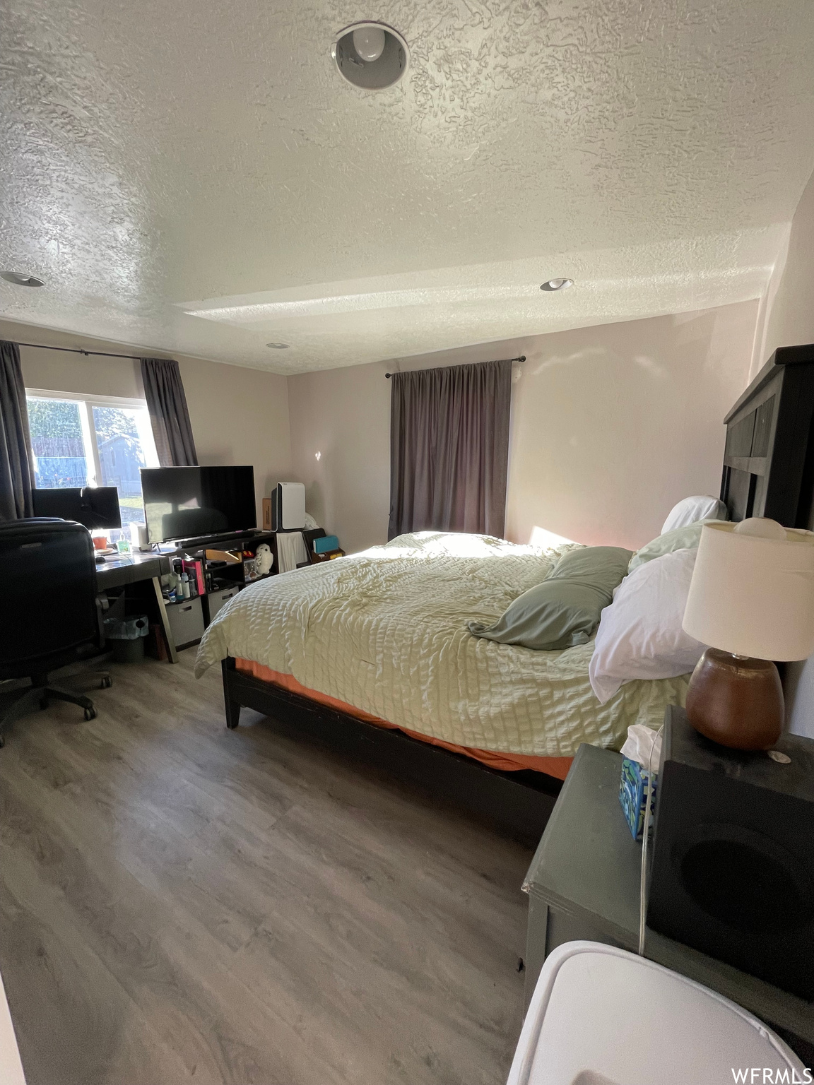 Bedroom featuring hardwood / wood-style flooring and a textured ceiling