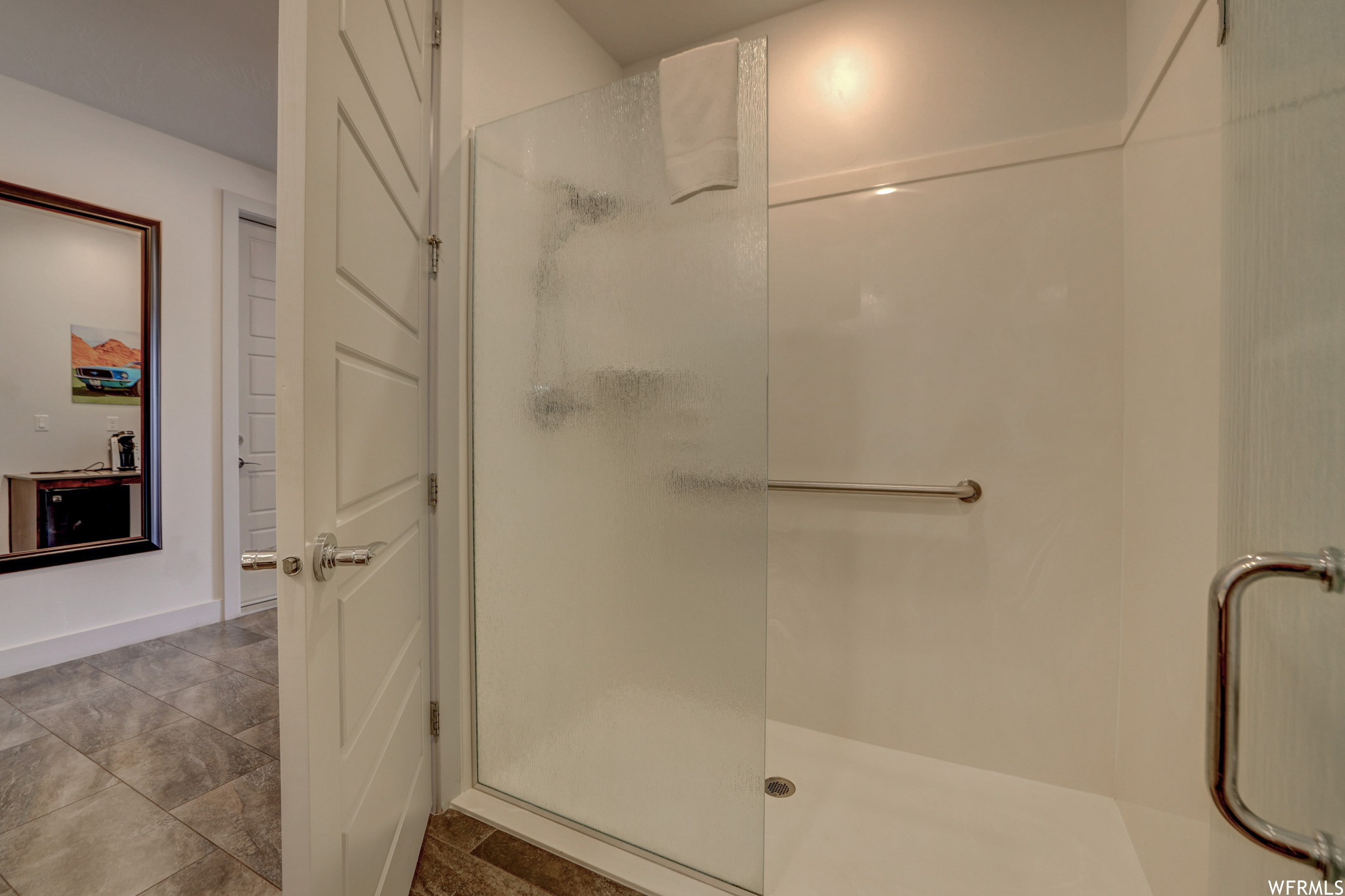 Bathroom with tile flooring and an enclosed shower