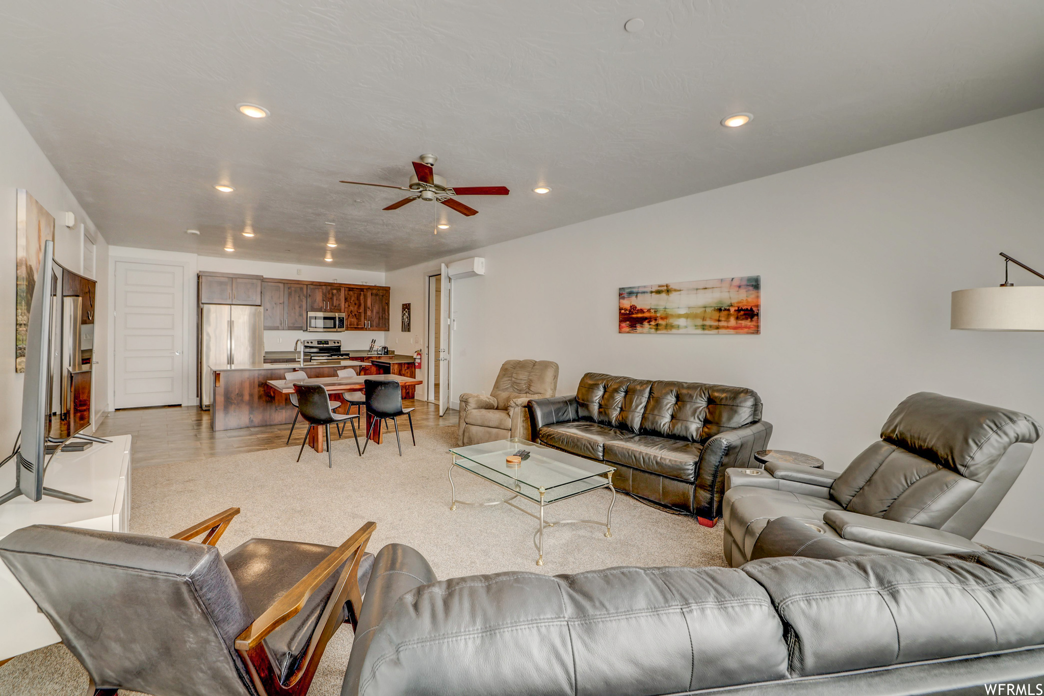 Living room with ceiling fan and light hardwood / wood-style floors