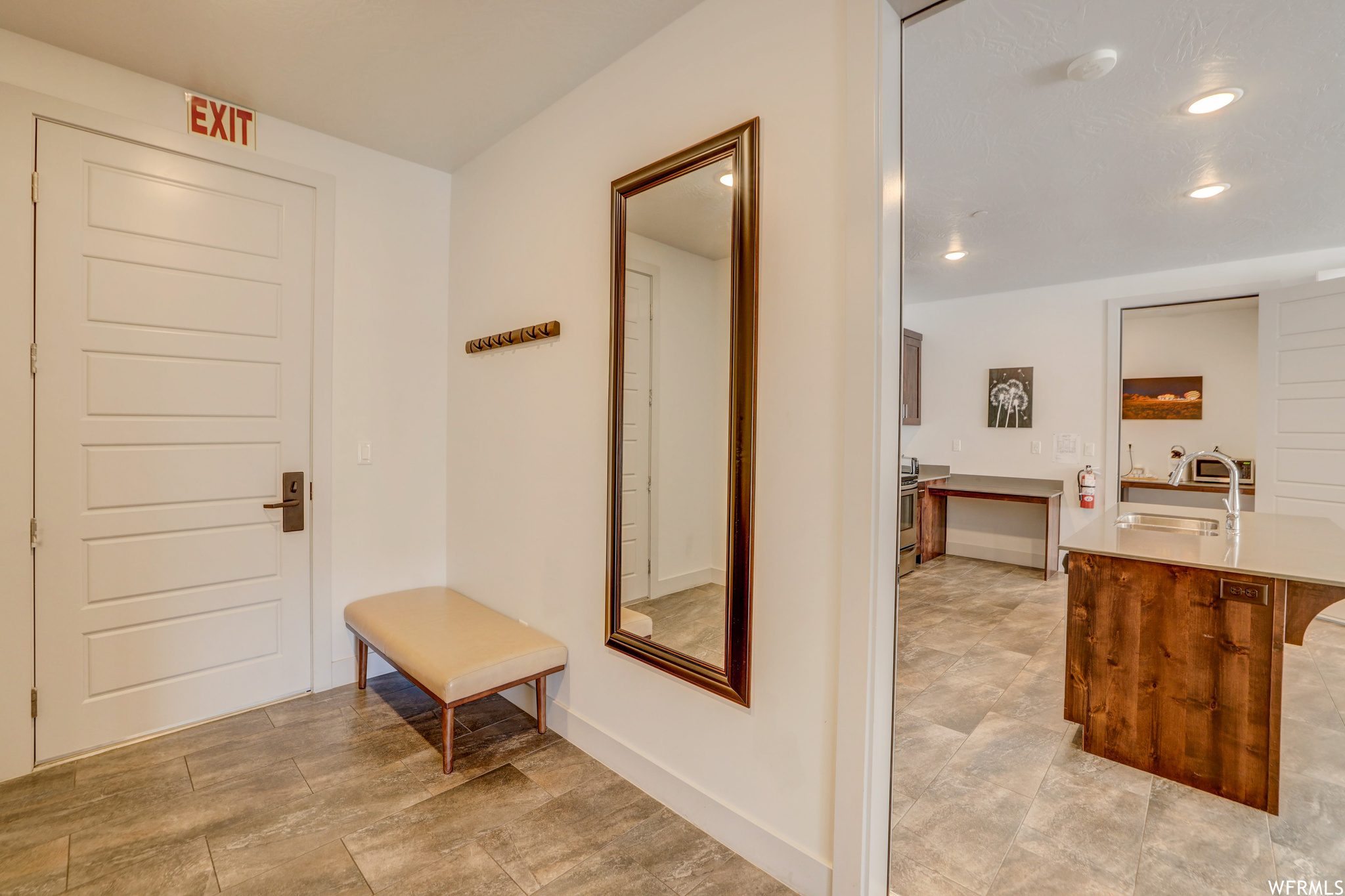 Mudroom with sink, built in desk, and light tile floors