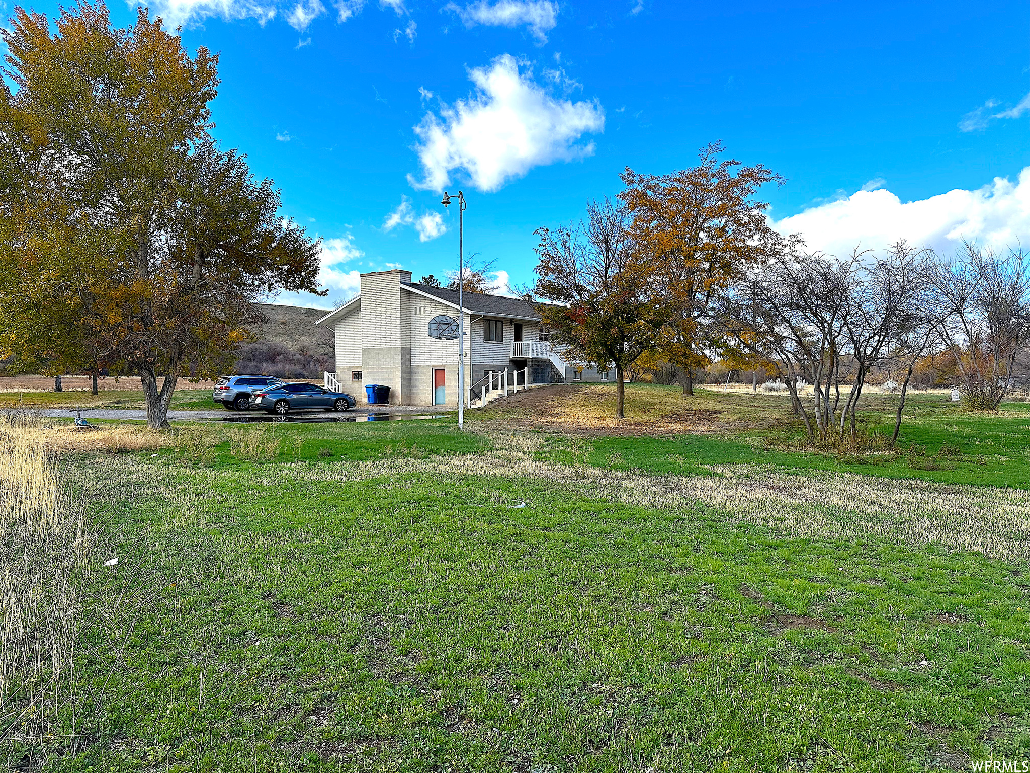 View of back yard, driveway and south side of home