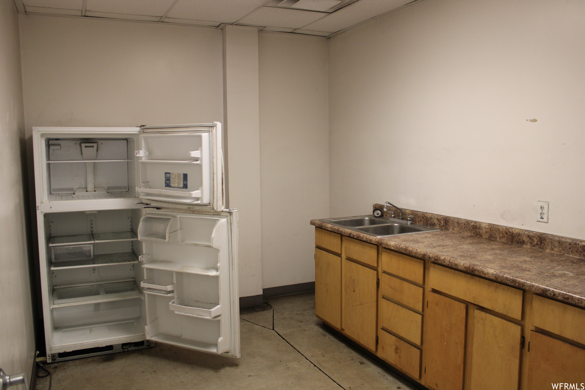 Kitchen featuring a drop ceiling, high end refrigerator, and sink