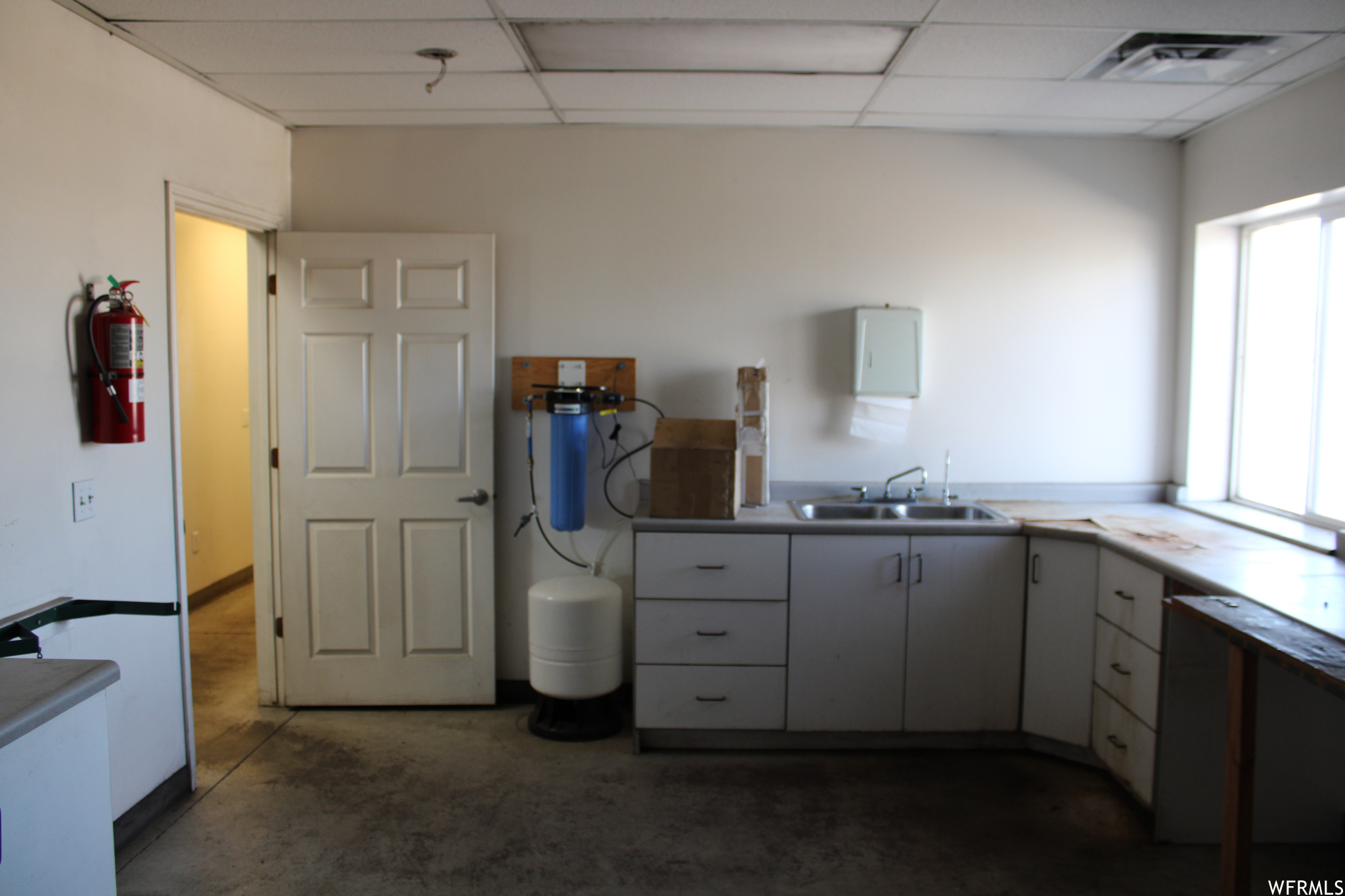 Kitchen area featuring sink, a healthy amount of sunlight, and a drop ceiling