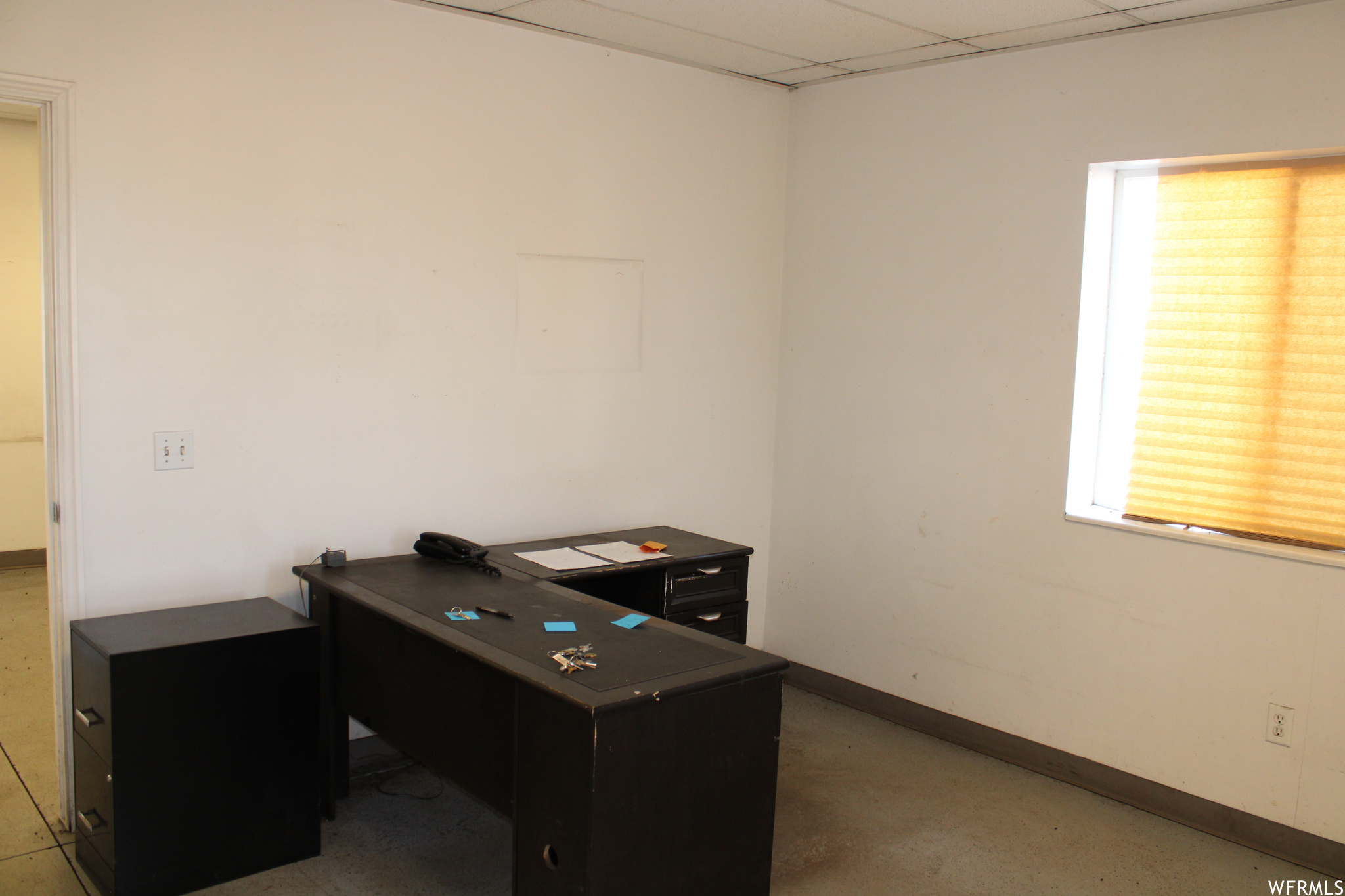 Office space with a paneled ceiling and a healthy amount of sunlight