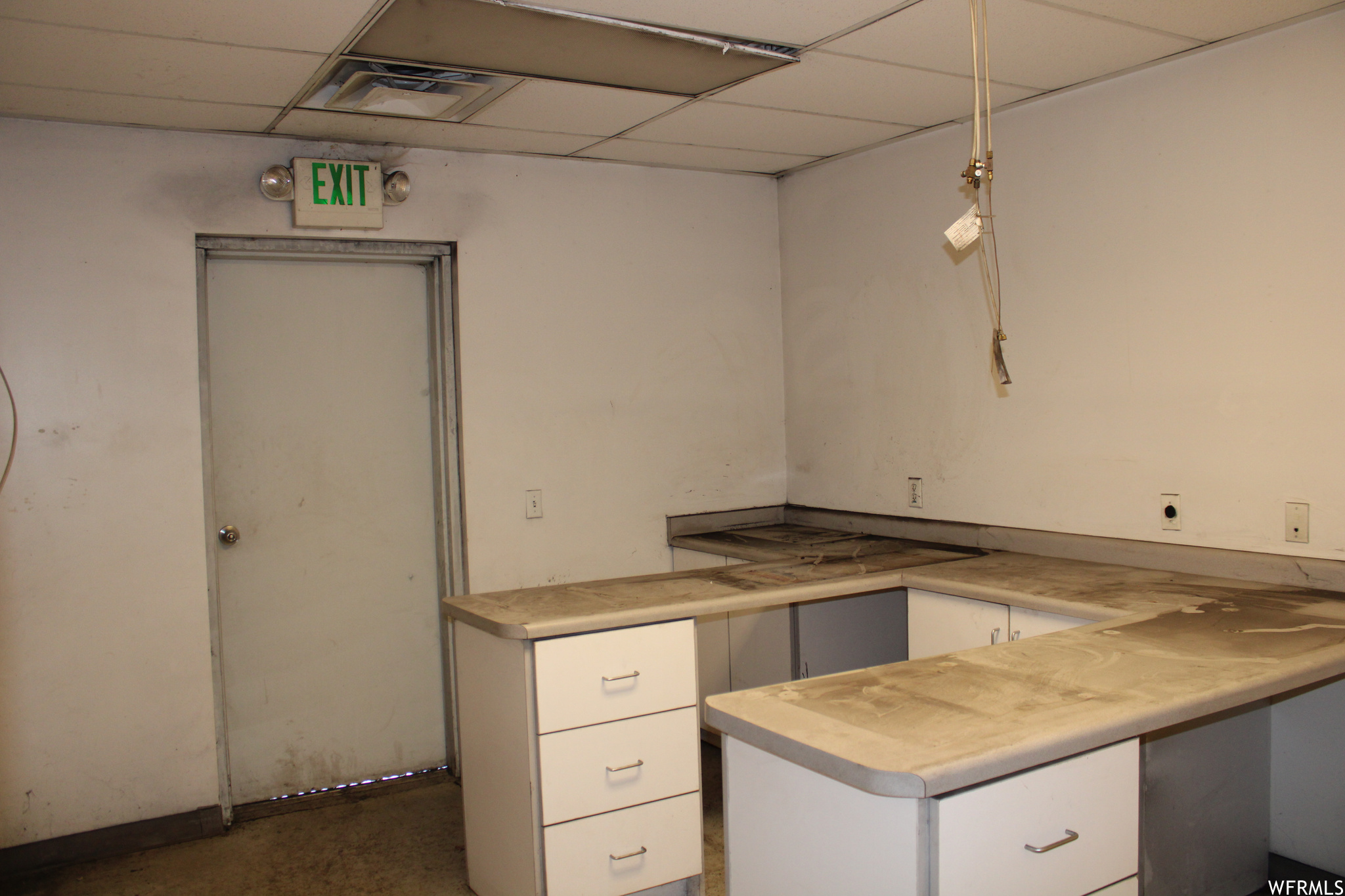 Room featuring white cabinets and a drop ceiling