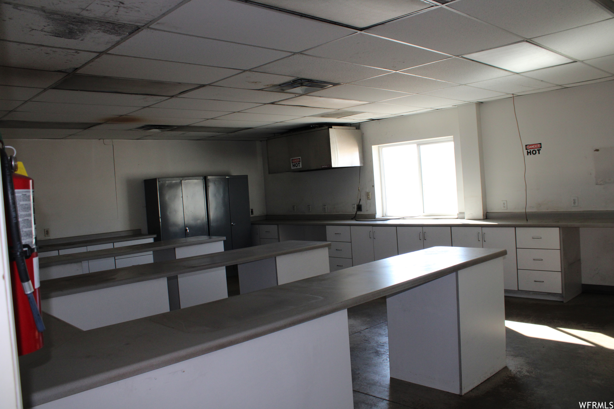 Room with a paneled ceiling, and white cabinets