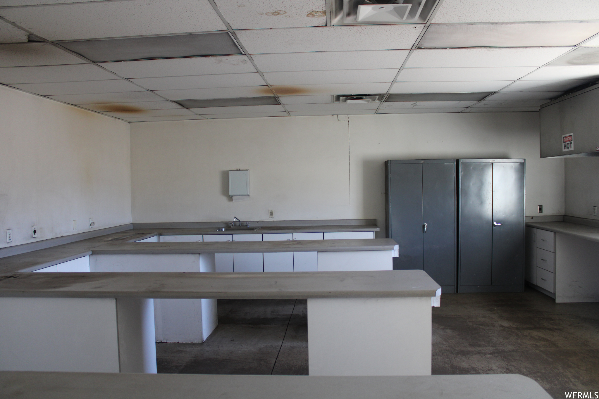 Misc room featuring sink, a drop ceiling, and dark tile flooring