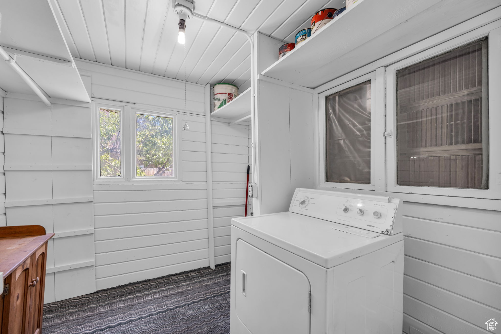 Refinished Washroom featuring wood walls and clothes dryer