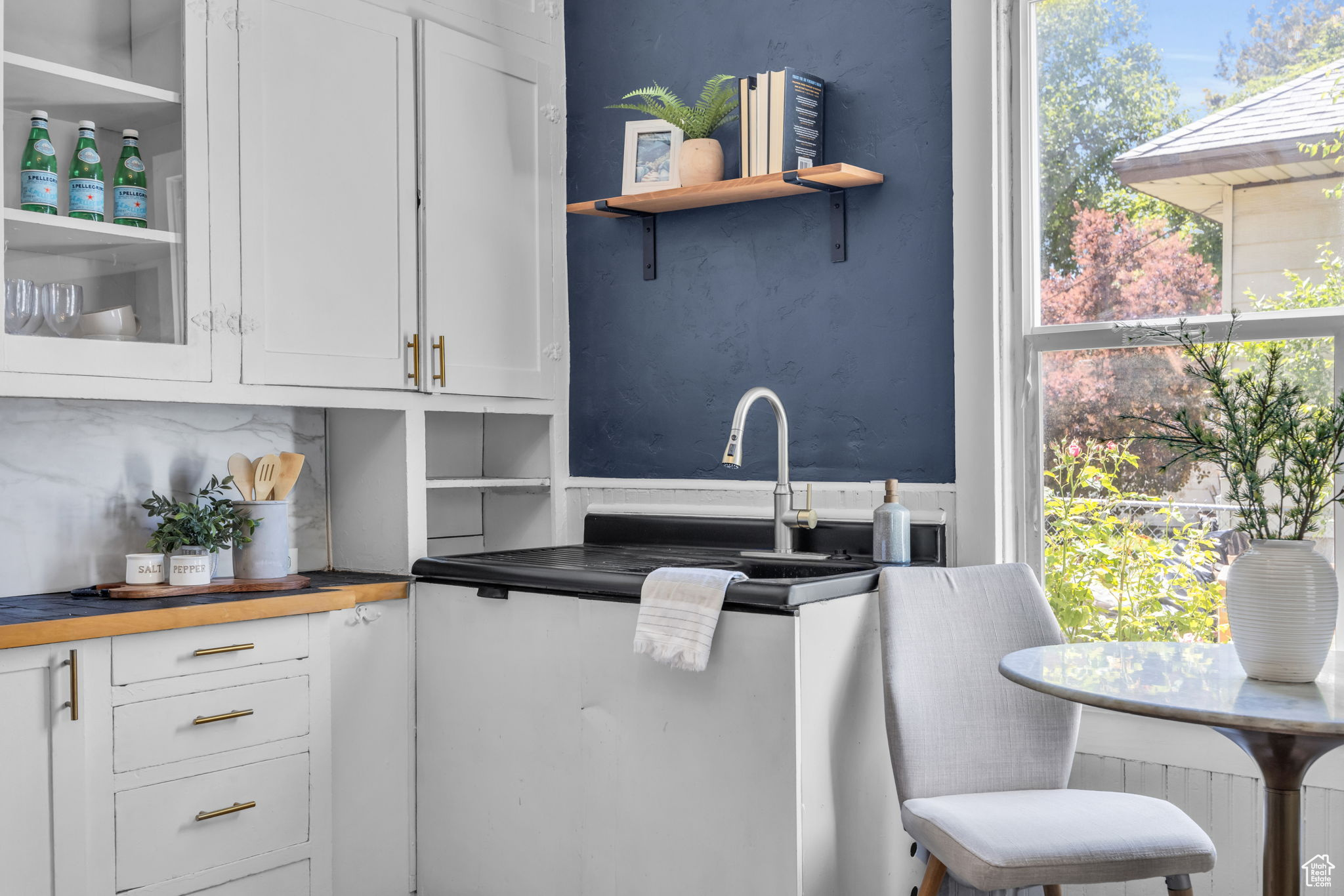 The kitchen features a refinished vintage sink, a new faucet, refinished kitchen cabinets, and new cabinet pulls.