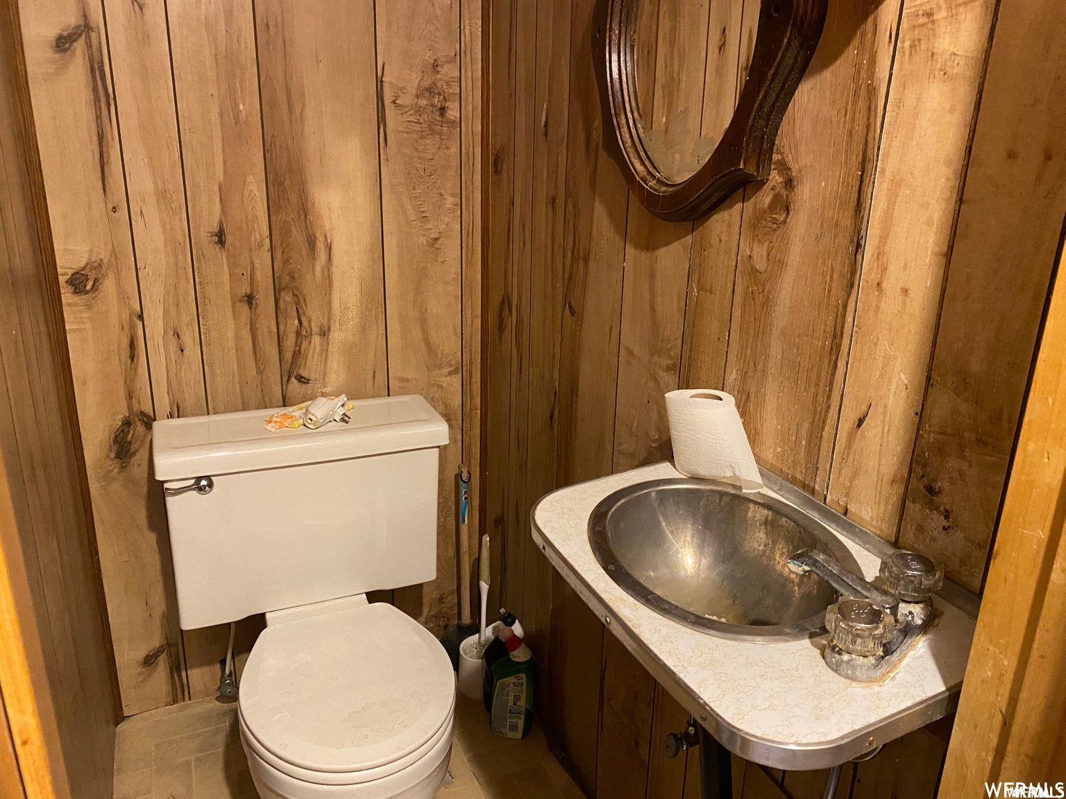 Bathroom featuring wood walls and toilet