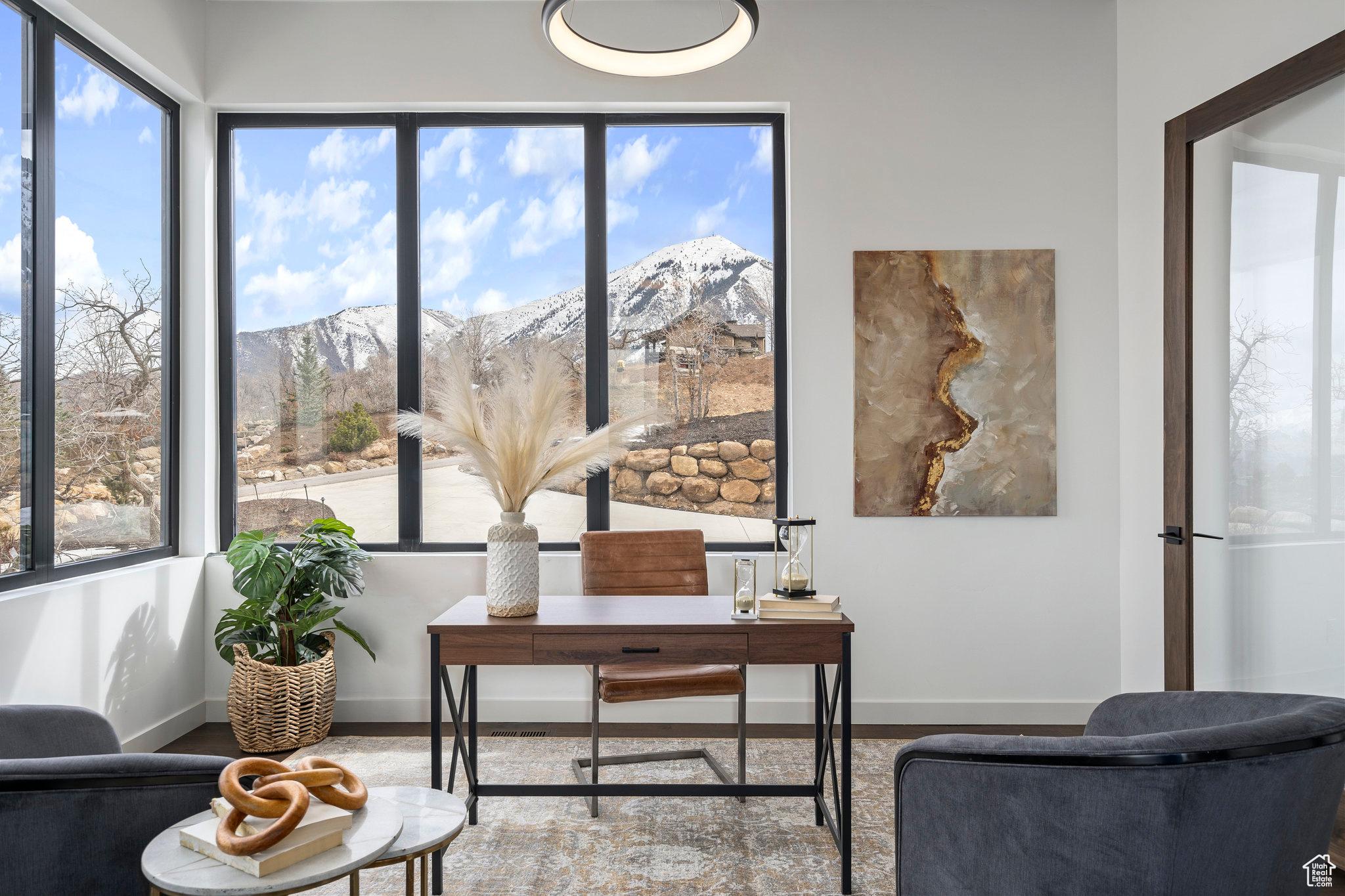 Office with large view windows glass doors to family room and entry hallway