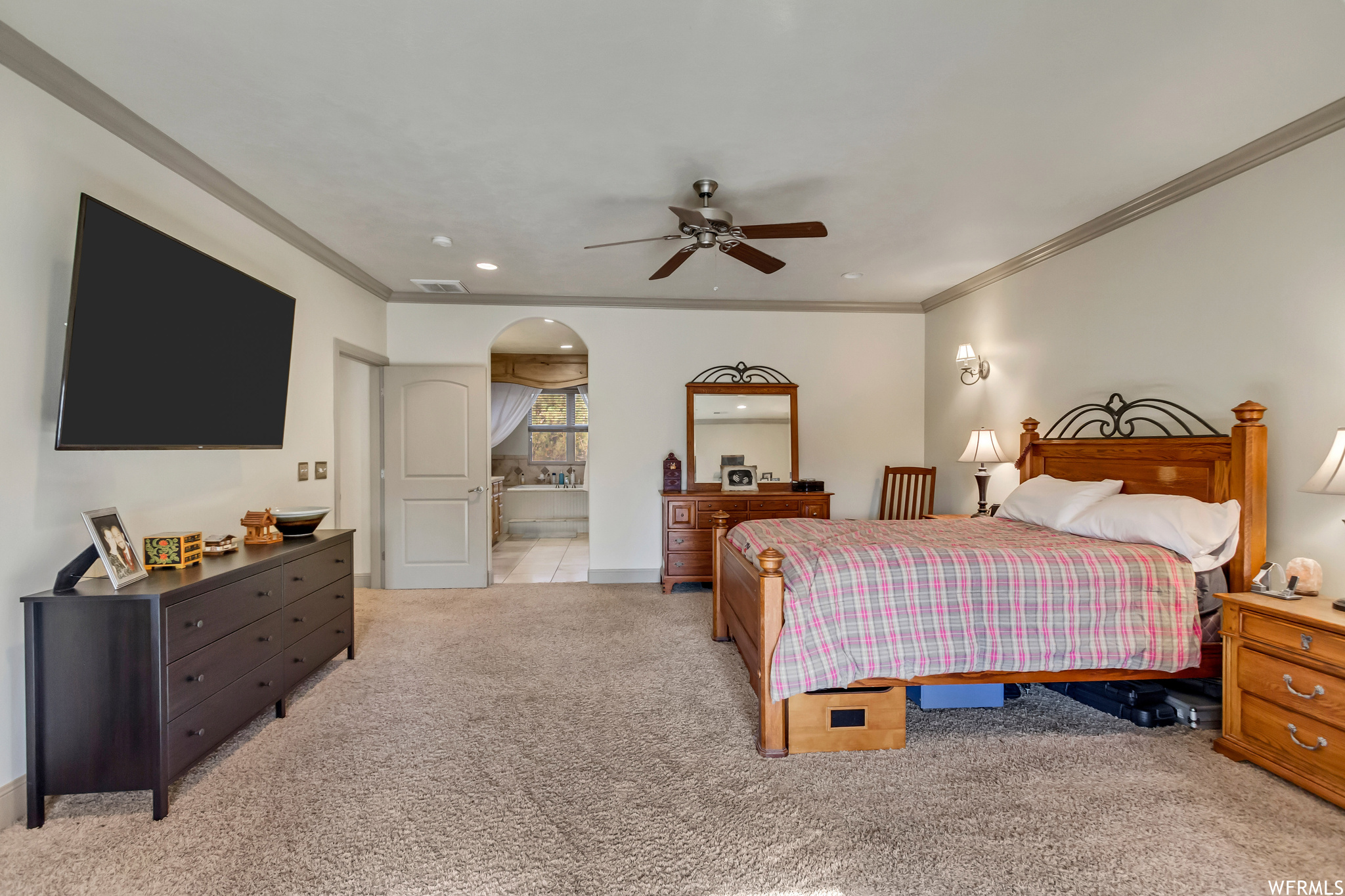 Carpeted bedroom featuring ensuite bathroom, crown molding, and ceiling fan