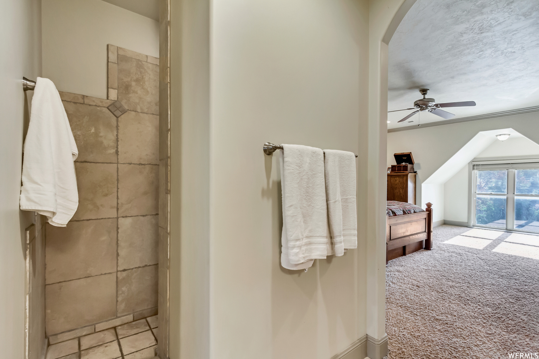 Bathroom featuring crown molding, ceiling fan, and a textured ceiling