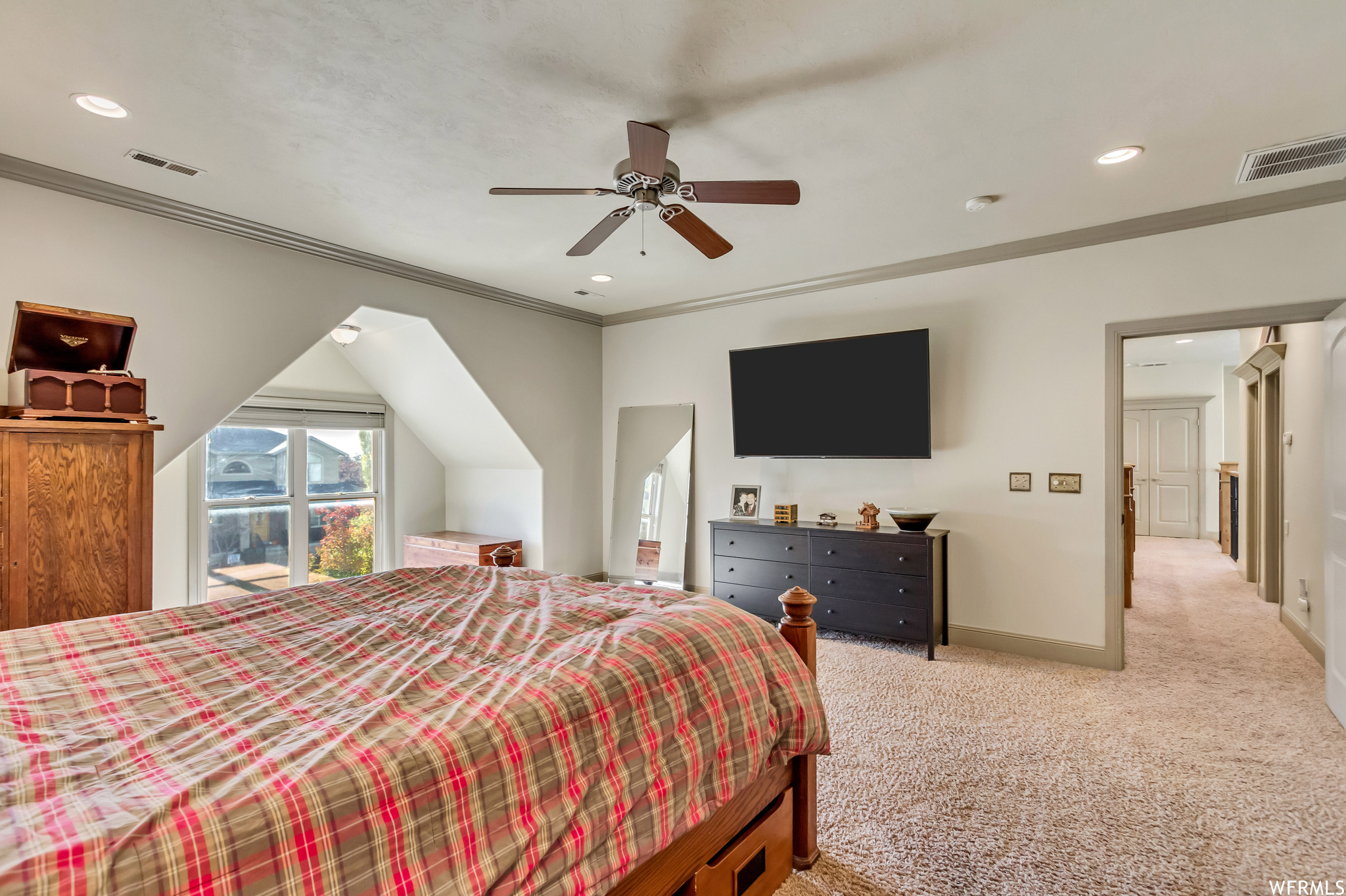 Bedroom featuring ceiling fan, light carpet, and crown molding
