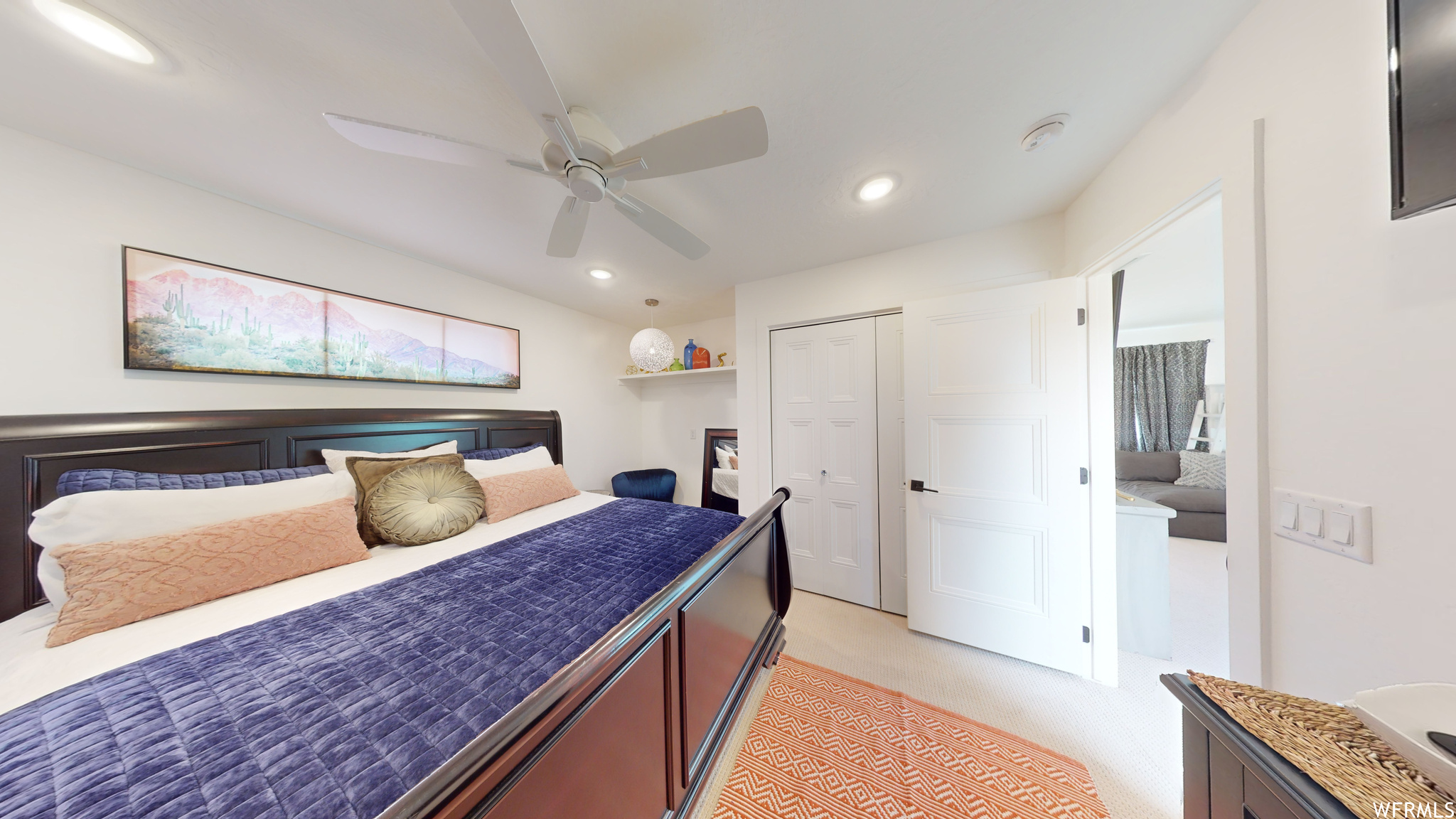 Bedroom featuring ceiling fan, light carpet, and a closet