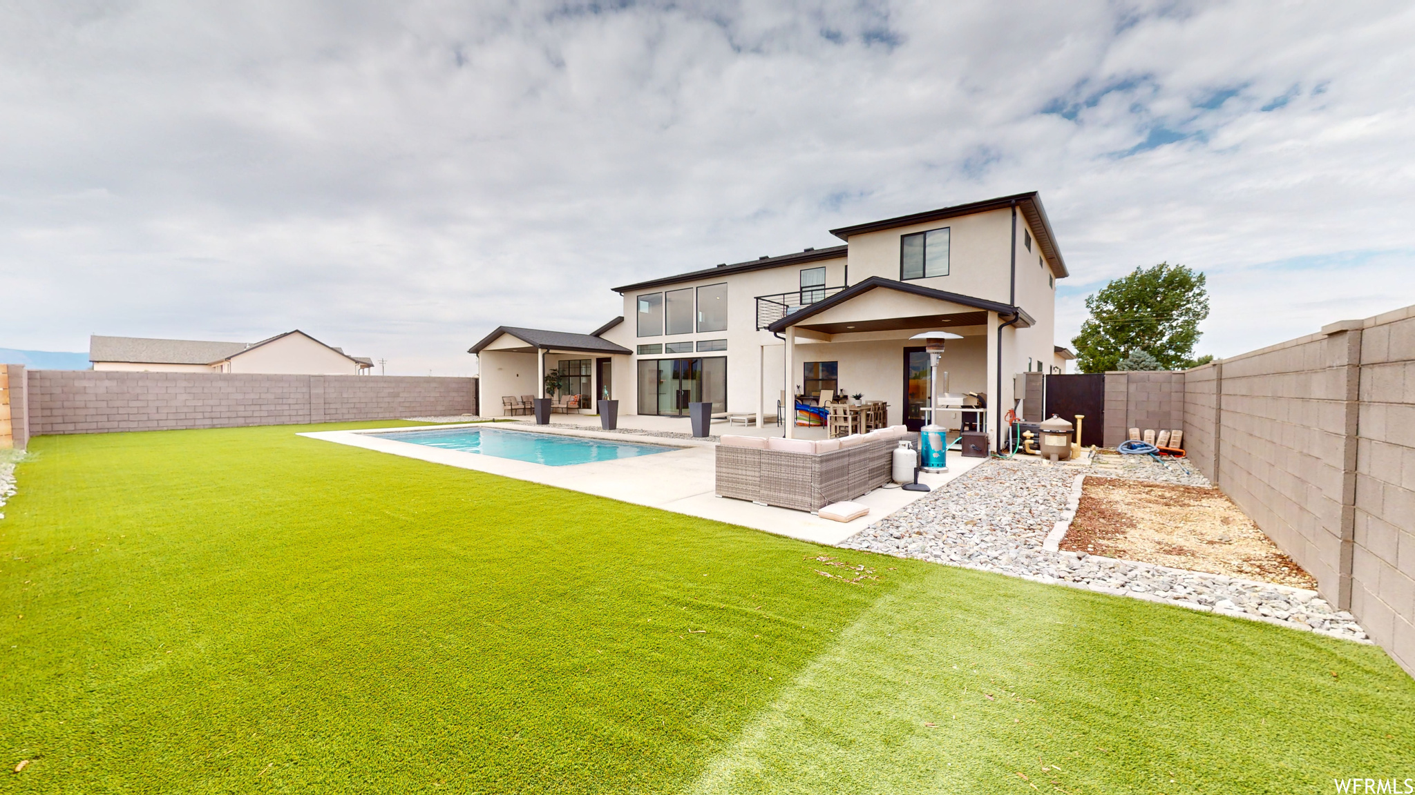 Rear view of house with an outdoor hangout area, a lawn, a fenced in pool, and a patio