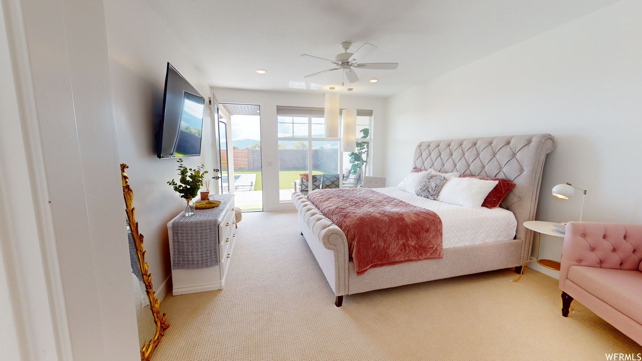 Bedroom with light carpet, ceiling fan, and access to outside