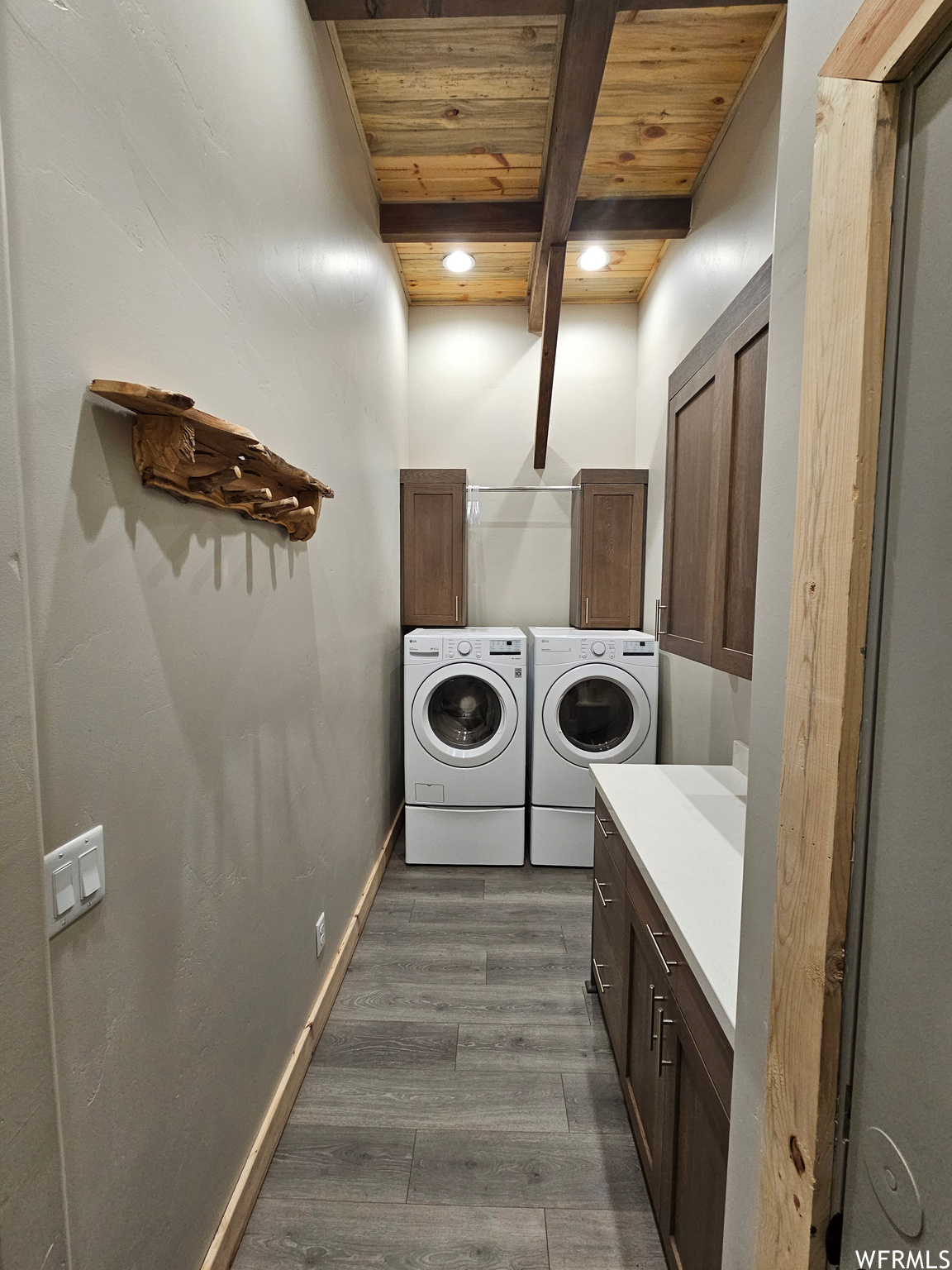 Large Laundry Room featuring cabinets and wood finishes
