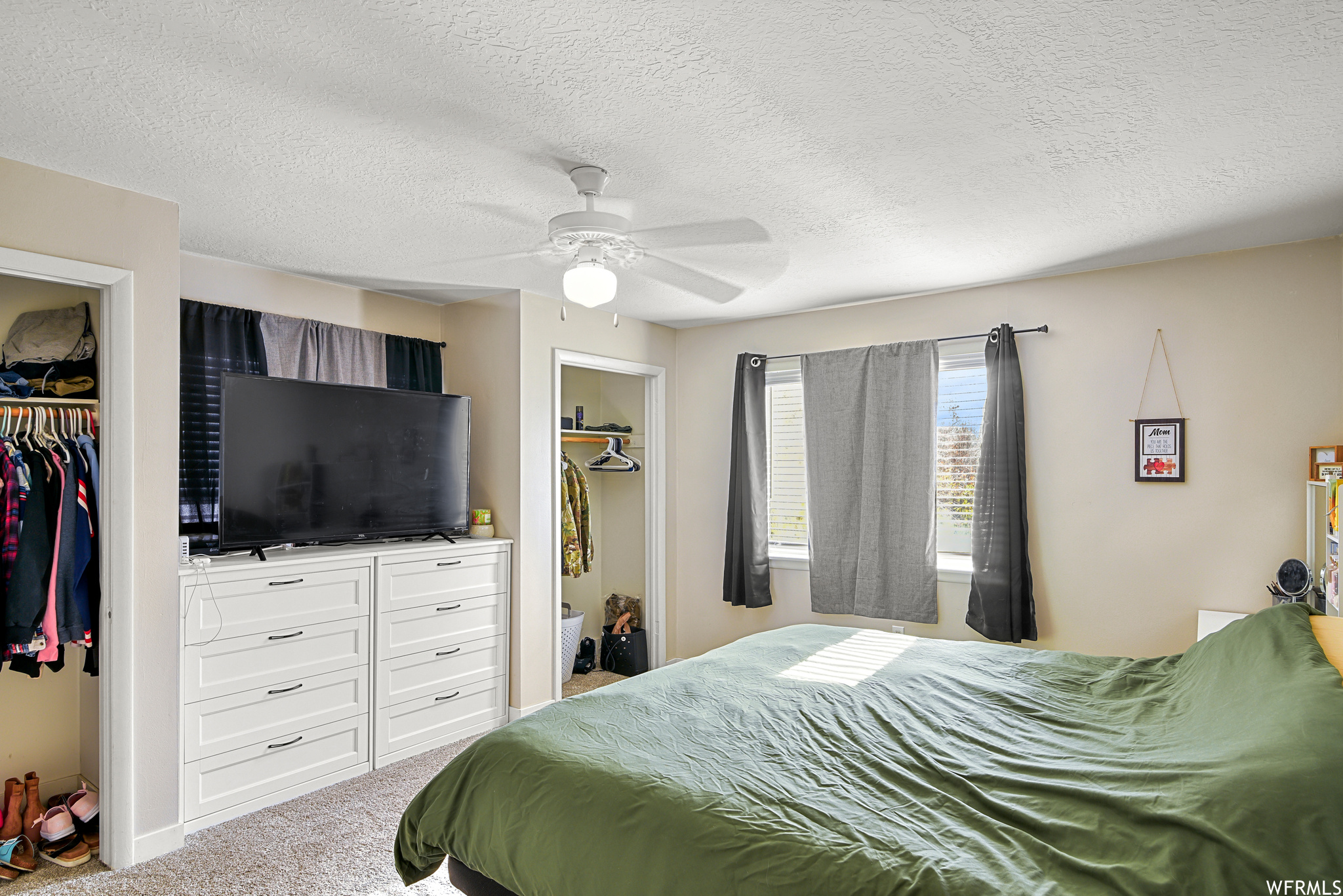 Carpeted bedroom featuring a closet, ceiling fan, and a textured ceiling