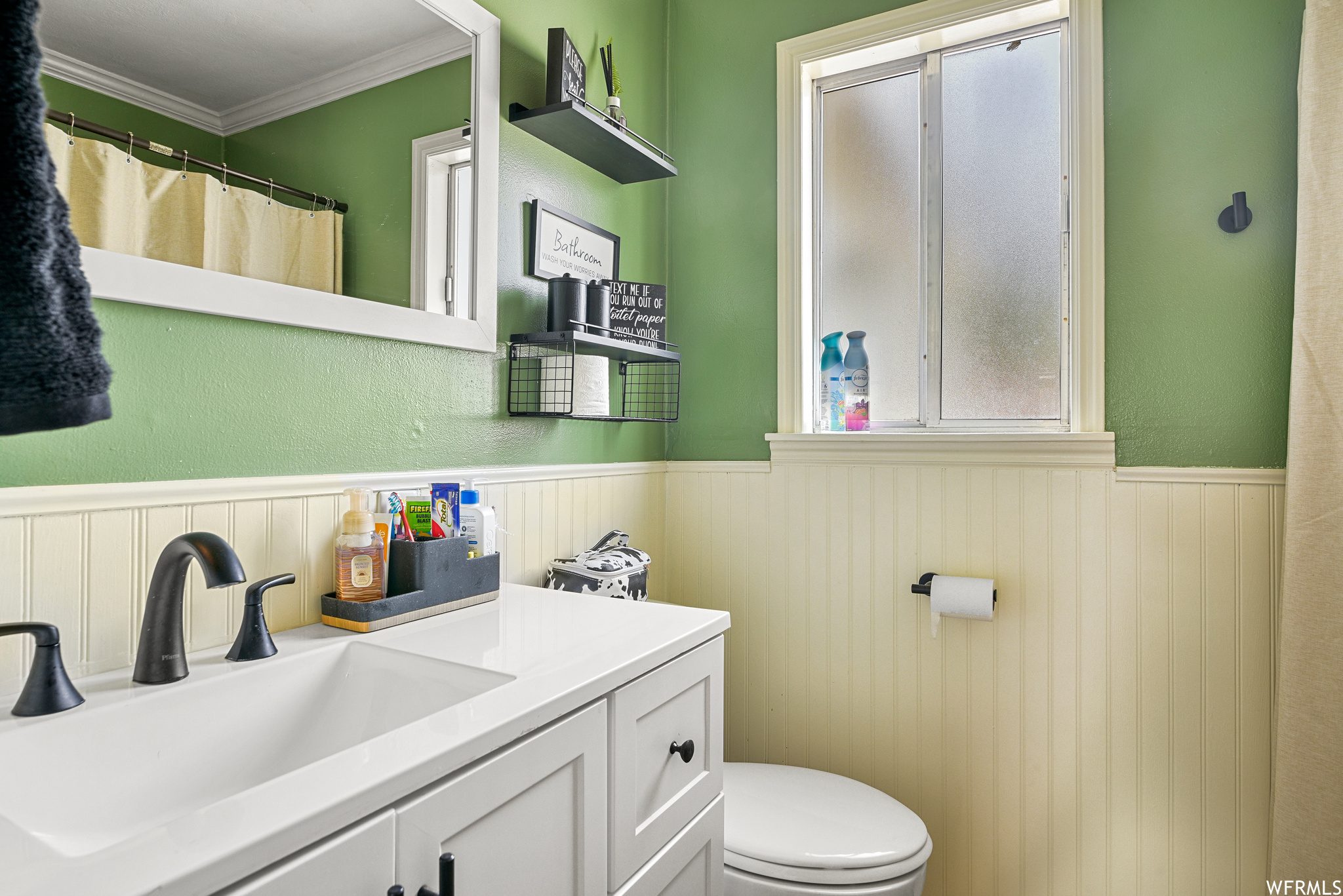 Bathroom featuring large vanity, toilet, and ornamental molding