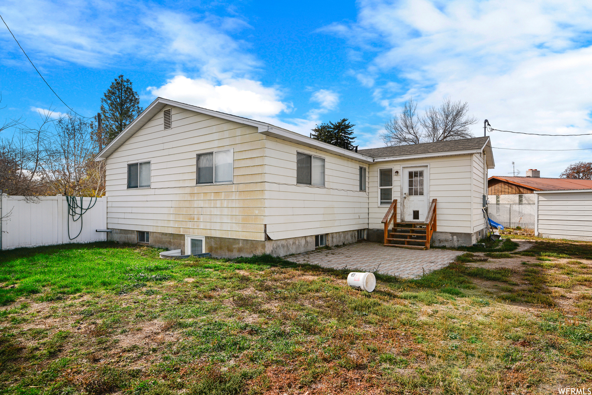 Rear view of house with a patio area and a lawn