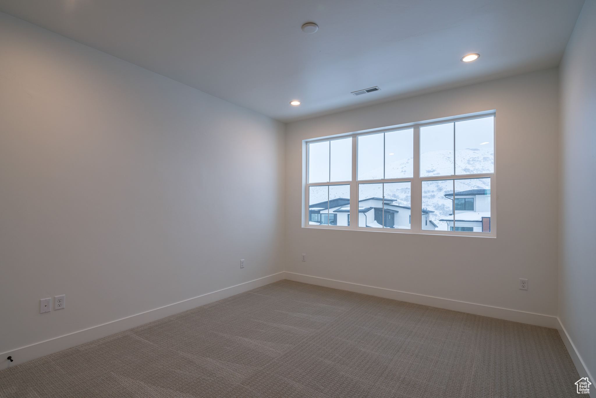 Spare room with plenty of natural light and light colored carpet