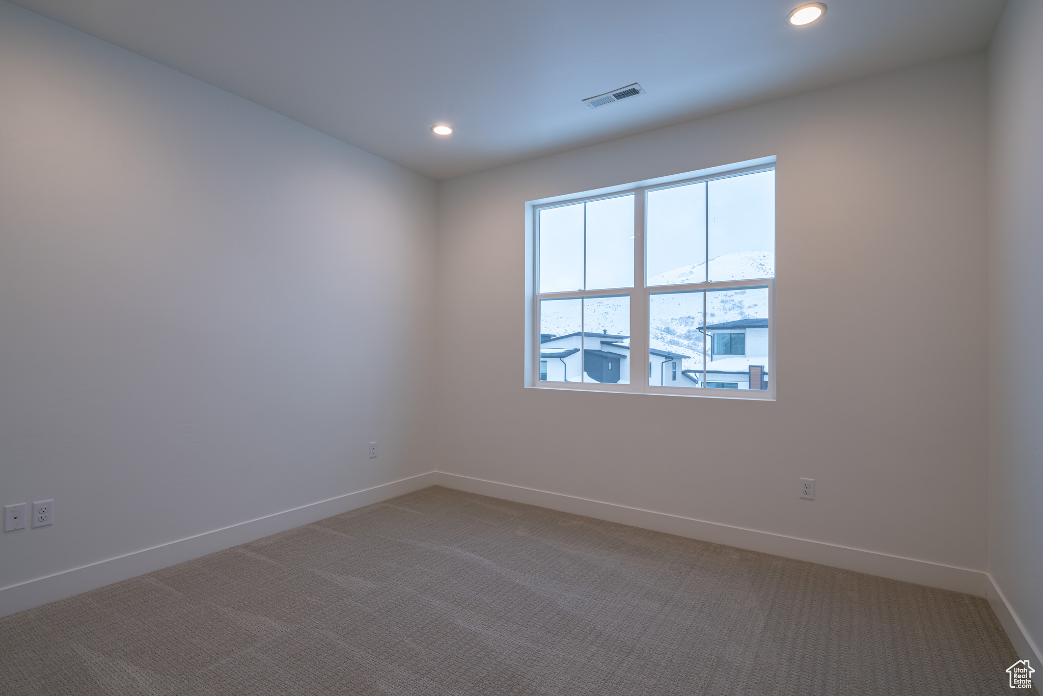 Empty room featuring light colored carpet