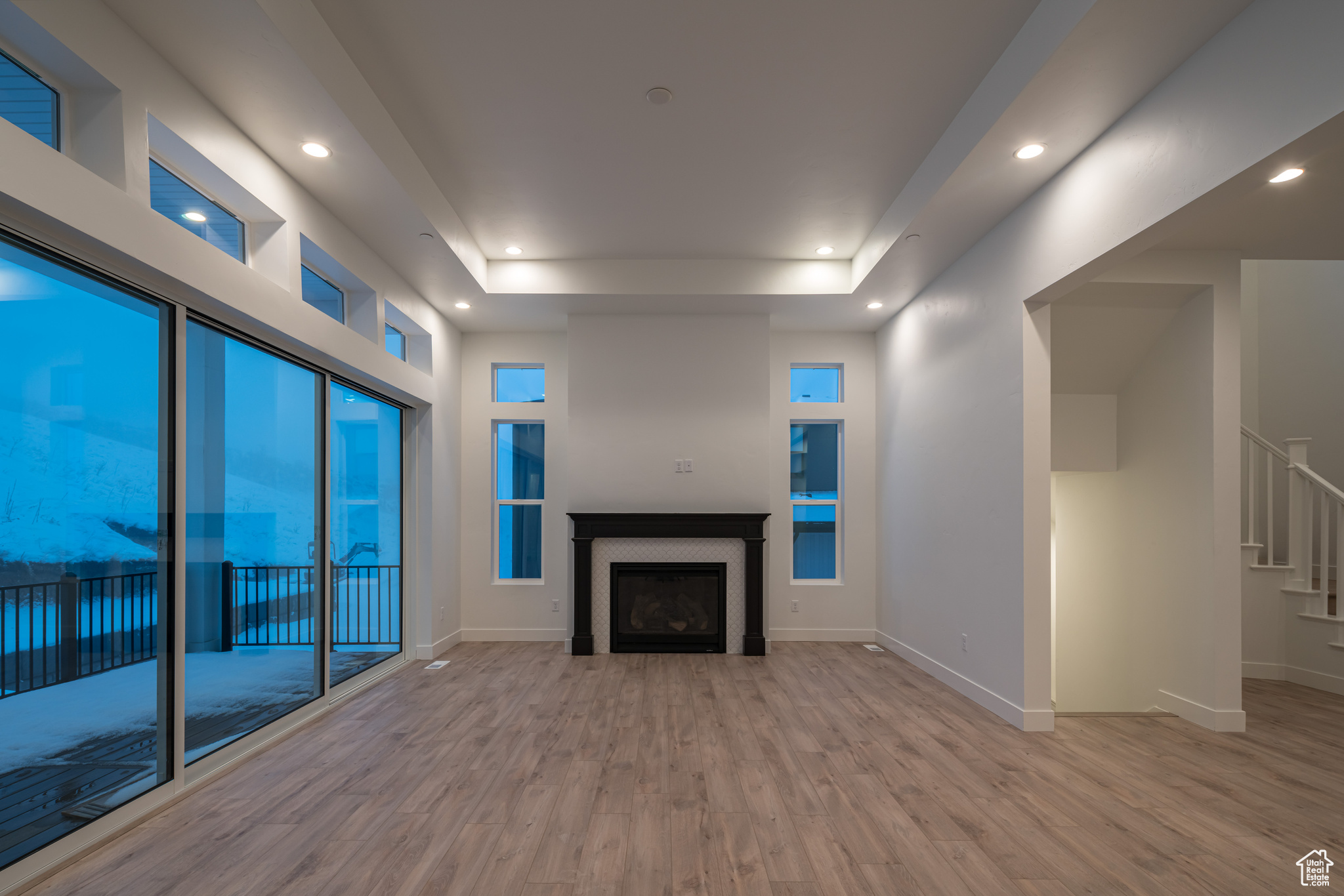 Unfurnished living room with light hardwood / wood-style floors and a tray ceiling