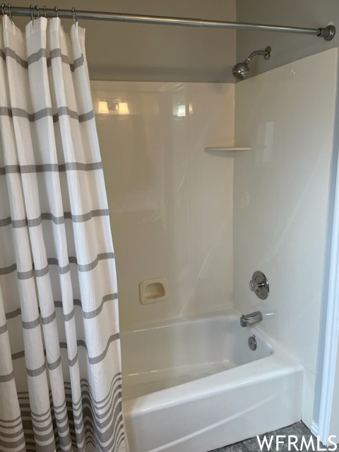 Bathroom with tile floors and shower / tub combo with curtain