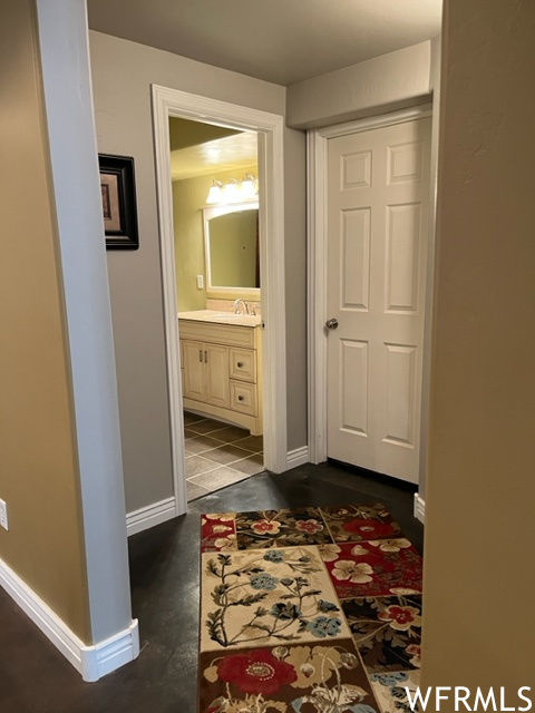 Hallway featuring dark tile flooring and sink