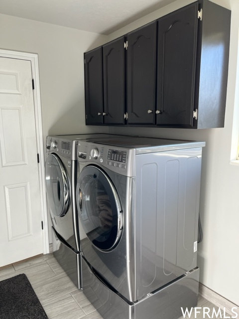 Laundry area featuring washer and clothes dryer and cabinets