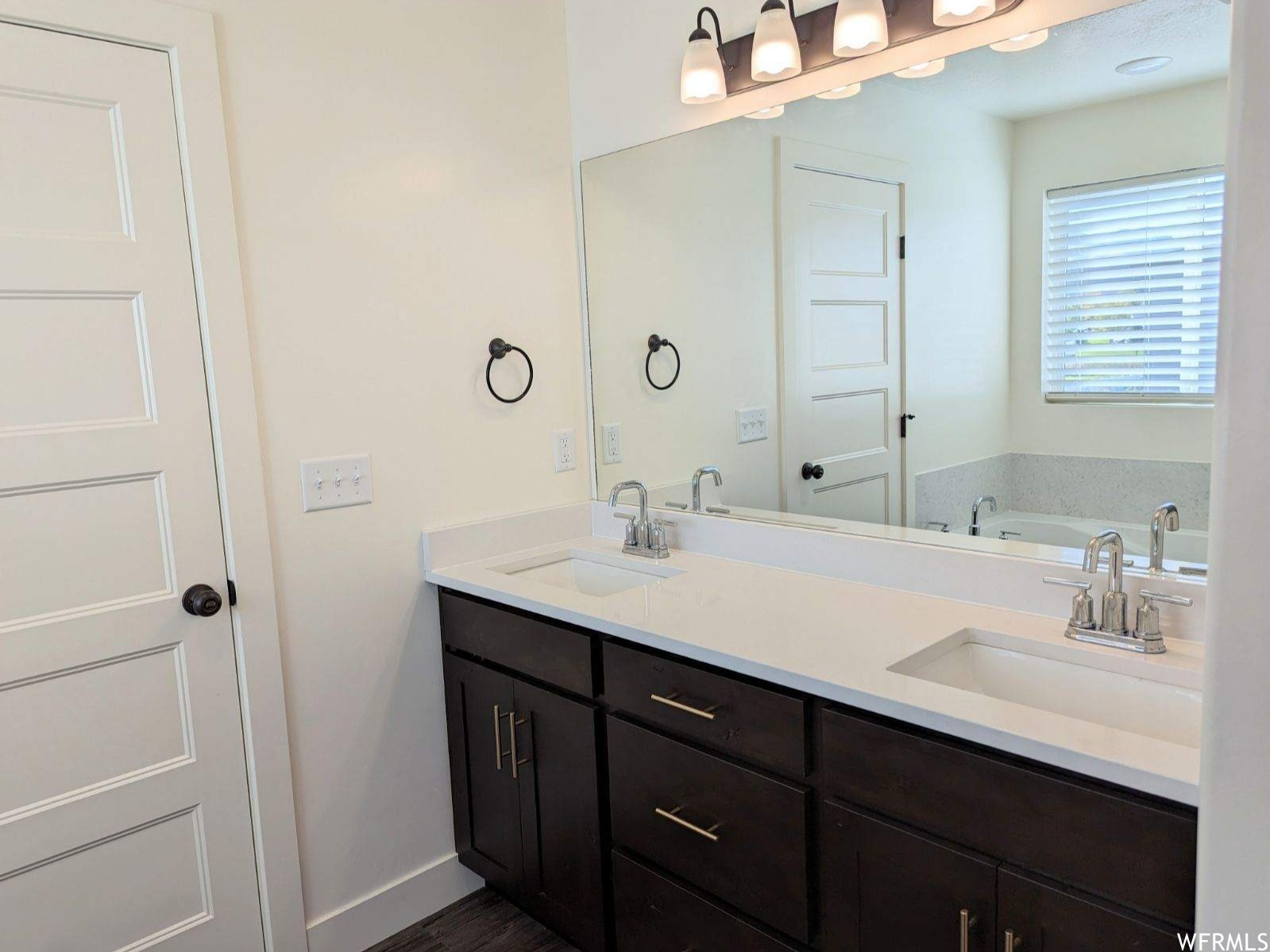 Bathroom featuring a tub and dual bowl vanity
