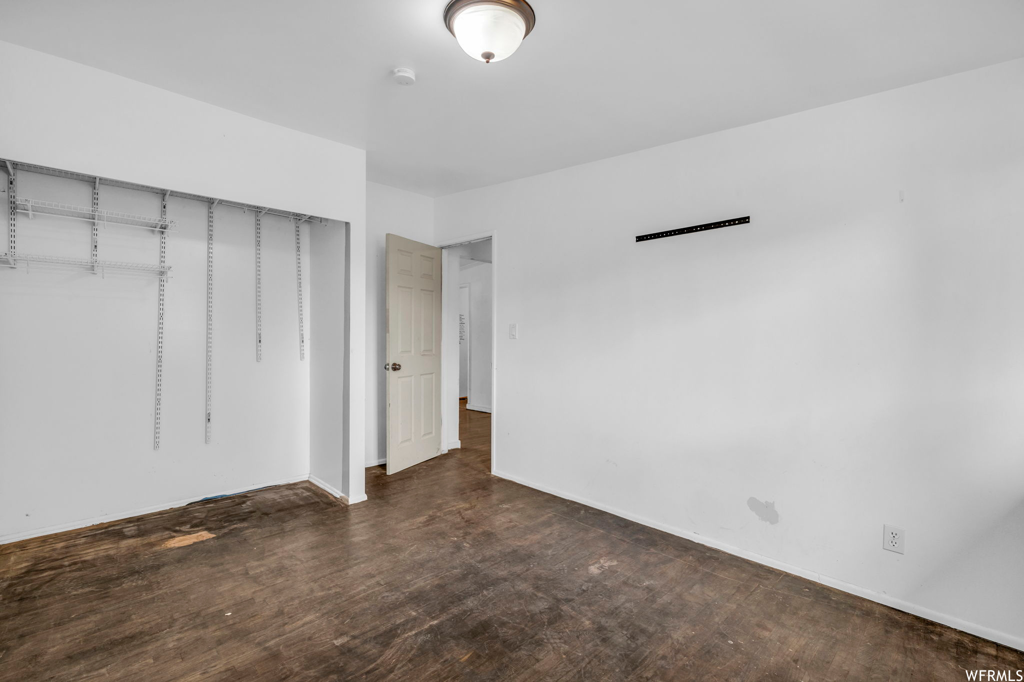 Empty room with dark wood-type flooring