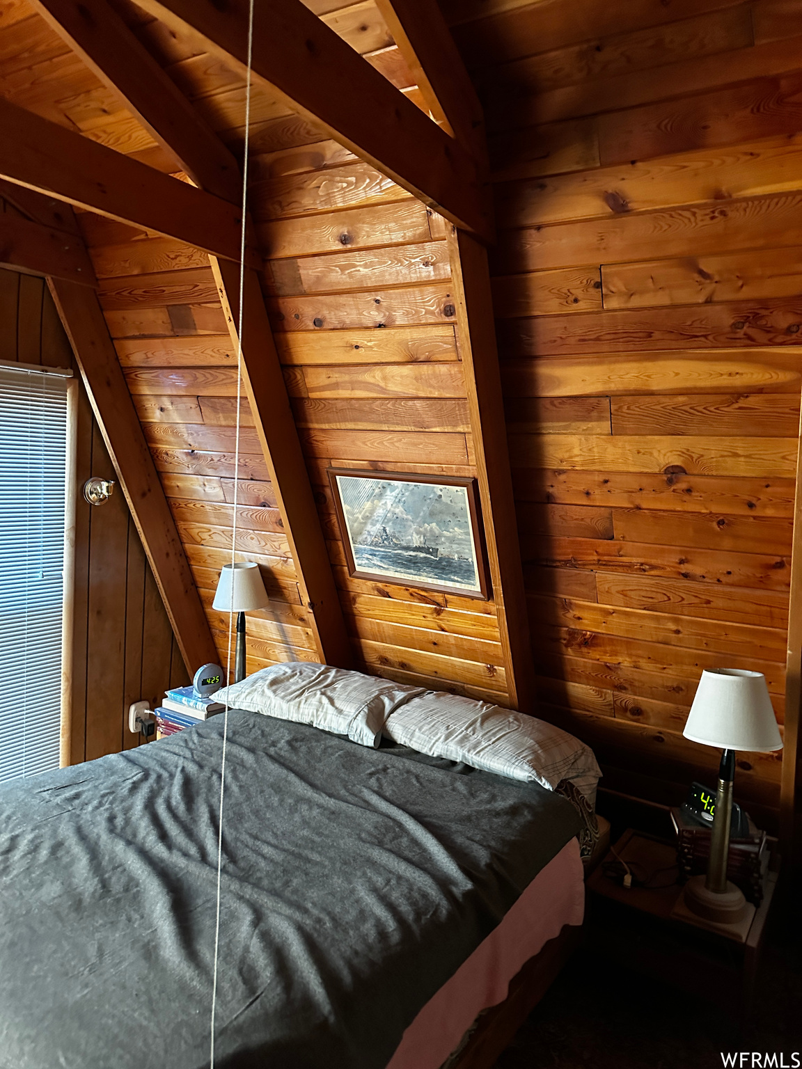 Bedroom featuring vaulted ceiling with beams, wooden ceiling, and wooden walls