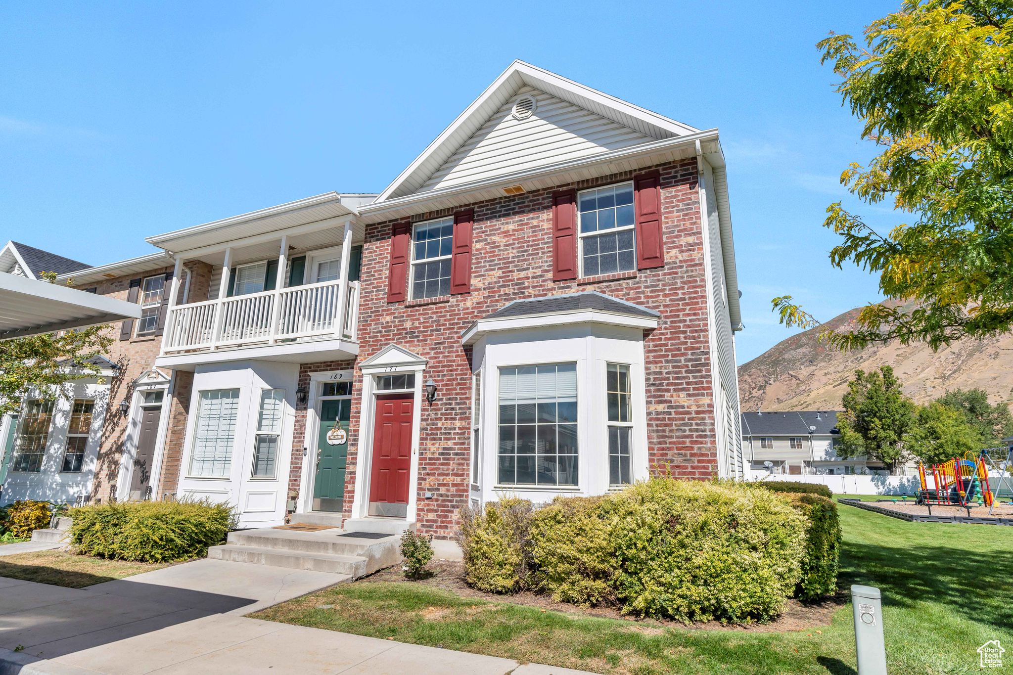 View of front of house with a front yard and a balcony