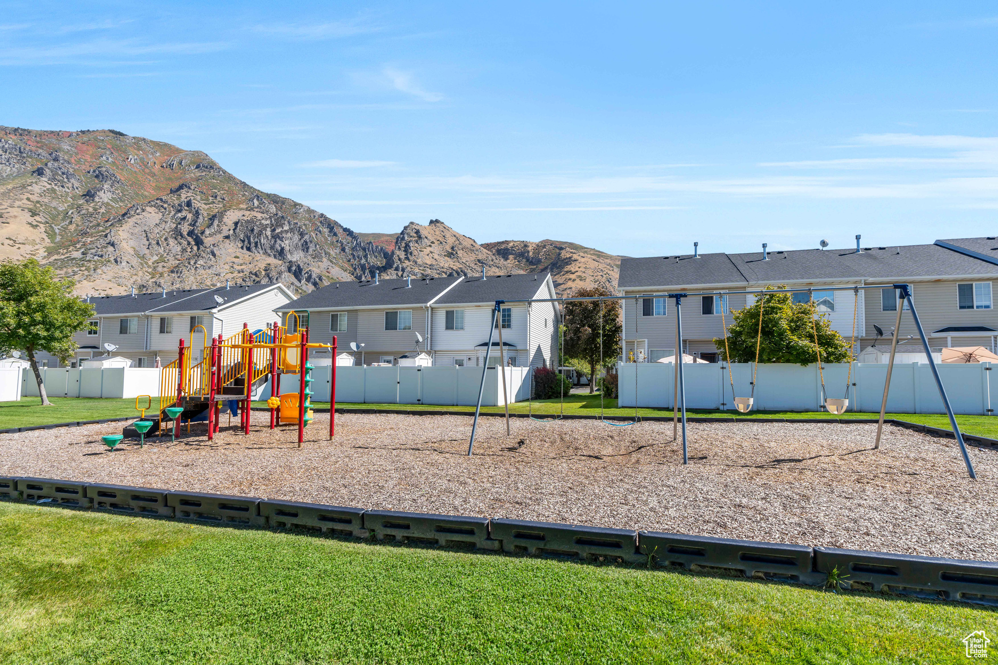 View of jungle gym featuring a lawn and a mountain view